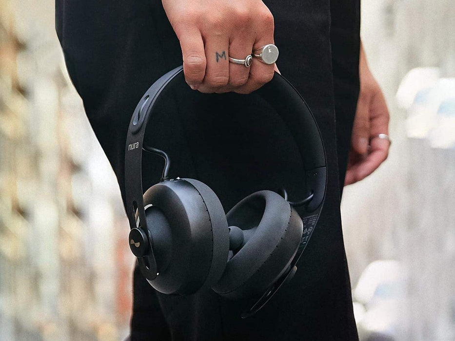 A photo of Nura Headphones held by a man showing close up the size of the headphones
