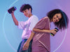 Image shows two people each holding a Soundcore by Anker Flare 2 Bluetooth Speaker