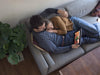 Image of the couple using notebook microsoft surface pro while resting on sofa