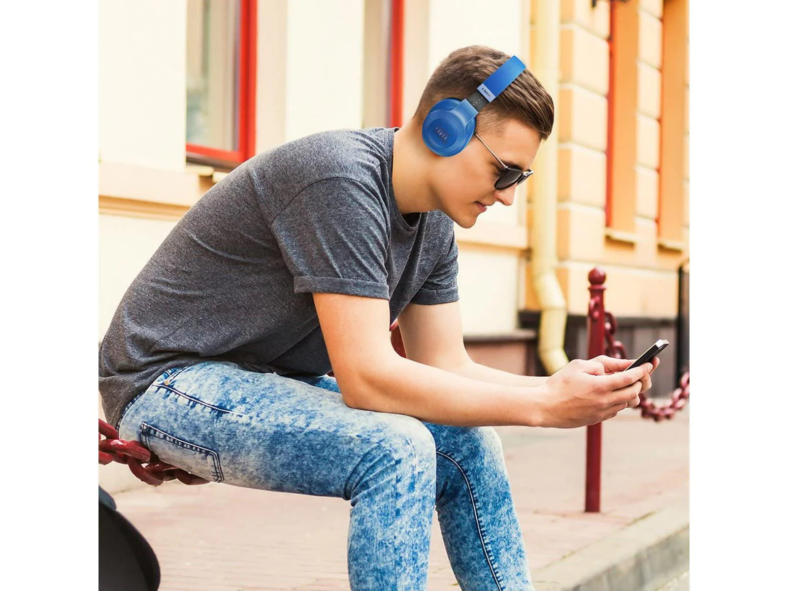 Photo of a man sitting on a railing listening to music using Bluetooth Wireless Headphones Over Ear Ergonomic Design Sound-Control-JBL